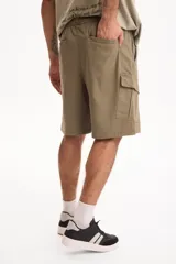 Bermuda cargo negra con cintura elastizada y cordón ajustable, de corte holgado y bolsillos laterales con solapa.