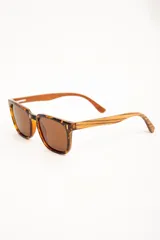 Lentes de sol polarizados con armazón transparente y patillas de madera, con cristales oscuros.