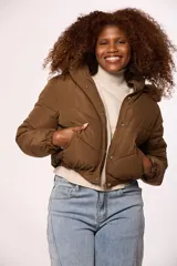 Campera bomber de nylon color rosado, con diseño acolchado, cierre frontal con cremallera y botones a presión, y capucha con borde de piel sintética al tono.