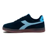 Championes urbanos Diadora modelo Bamtelo para mujer, confeccionados en gamuza color azul marino con detalles en celeste claro en los laterales, lengüeta y talón. Cuenta con suela translúcida de goma y cordones al tono.