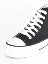 Zapatilla de caña alta con plataforma, confeccionada en lona negra con cordones y puntera de goma blanca.