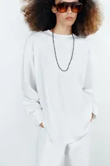 Camiseta oversize de manga larga color rosado, con cuello redondo y bajo recto.
