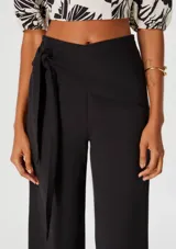 Pantalón color beige de corte recto, con cintura alta y lazo lateral.