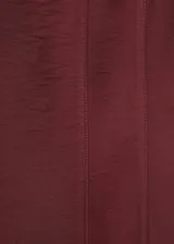 Vestido midi color bordó con diseño evasé, tirantes anchos y cuello cuadrado. Presenta costuras decorativas verticales y cierre de cremallera en la parte posterior.