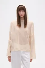 Canguro de tejido de punto calado en color crudo, con capucha, mangas largas y corte holgado.