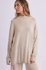 Sweater de punto color beige melange, de corte amplio y cuello alto.