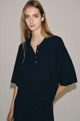 Camiseta polo de manga corta, color azul marino, con cuello solapa y cierre frontal de cuatro botones.