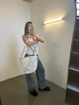 Zuecos negros de cuero encerado con detalle de tachas plateadas en la base y hebilla metálica en el empeine.