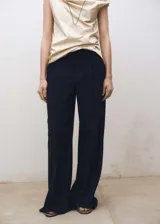 Pantalón de vestir negro, de corte wide leg, tiro medio, con trabillas y pinzas frontales. Cierre frontal oculto con botón, gancho y cremallera. Confeccionado en tejido mezcla de lana con forro interior.