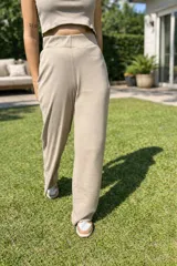 Pantalón largo de tejido de punto color beige, tiro alto y calce ancho y relajado.