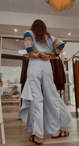 Pantalón de jean azul oscuro con diseño fluido y volados en las piernas.