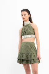 Top corto verde militar con cuello halter y detalles de encaje en cuello y cintura.