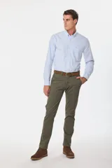 Pantalón de gabardina color marrón claro, corte slim fit, con bolsillos laterales y traseros. Se ajusta a la cintura con cinturón de cuero marrón.