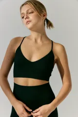 Top deportivo de tejido acanalado con escote en V y breteles finos regulables. Diseño sin costuras con ajuste al cuerpo.