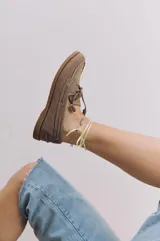 Zapato náutico de cuero color marrón claro, con cordones y suela de goma.
