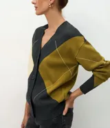 Cardigan de punto con diseño geométrico de rombos en tonos gris, verde oliva y crema. Presenta escote en V, cierre frontal con botones y mangas largas con puños acanalados.