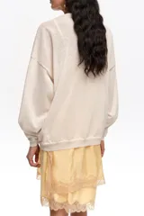 Jersey largo de corte recto confeccionado en mezcla de lino y algodón. Presenta un escote en V pronunciado con detalle de encaje al tono y mangas largas con forma.