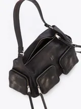 Cartera de hombro confeccionada en cuero vacuno color bordó con acabado desgastado. Presenta múltiples bolsillos exteriores con cierre en el frente, dorso y laterales, herrajes metálicos plateados y logo de la marca aplicado en el frente.