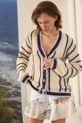 Cardigan de punto a rayas color beige con detalles en marrón y celeste, escote en V con bordes ondulados, cierre frontal de botones y mangas largas.