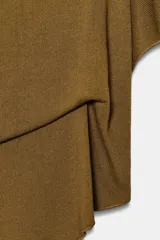 Top tipo capa blanco de punto fluido, con mezcla de viscosa, cuello bote, mangas cortas y bajo asimétrico.