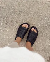Sandalias negras con diseño de tiras anchas entrelazadas.