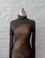 Vestido corto de microtul elastizado en color marrón con efecto degradado. Presenta cuello alto, mangas largas con terminación acampanada y bordes con acabado ondulado.