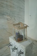 Necessaire transparente de PVC con bordes y asa en tela color beige, cierre superior con cremallera.