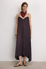 Vestido midi color morado oscuro, confeccionado en tejido satinado con efecto plisado o arrugado. Presenta escote en pico y tirantes finos ajustables. El calce es fluido y holgado.