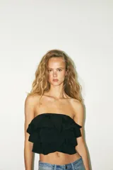 Top bandeau color crema con escote recto, hombros descubiertos y detalle de volantes en capas.