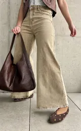 Pantalón de jean color beige con efecto óxido, de tiro alto y corte ancho en las piernas.