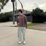 Sweater de punto con diseño bicolor y texturas combinadas, presenta un lado de tejido liso y otro con trenzado vertical. Posee cuello redondo, corte holgado y una etiqueta decorativa en el frente.