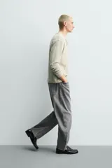 Jeans de denim de algodón en color negro con efecto lavado, corte amplio y silueta curva tipo barrel fit con pinzas en las rodillas. Presenta diseño clásico de cinco bolsillos y cierre frontal con cremallera y botón metálico.