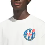 Remera de algodón color blanco con cuello redondo y corte holgado. Presenta un pequeño logo estampado en el pecho y un diseño gráfico grande en la espalda con el logo de Adidas y la inscripción Adidas World Class Basketball Exhibition.