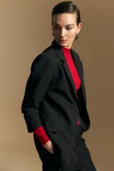 Blazer de corte sastrero con solapas clásicas y estructura definida. Presenta un diseño versátil con silueta ligeramente oversized, ideal para un estilo sofisticado y atemporal.