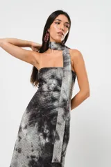 Vestido largo strapless con estampado batik en tonos grises y negros. Incluye una tira de tela que se puede usar como cuello halter. Tiene tajo en ambos costados.