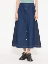 Pollera midi de denim azul con recortes laterales en denim más oscuro, acceso frontal con broches metálicos y bordado JCH en la cintura trasera.