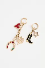 Aro colgante dorado con dije de corazón rojo, trébol de cuatro hojas con pedrería y herradura con gemas de colores.