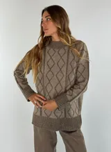 Sweater de lana color bordó con cuello alto y diseño de rombos y líneas verticales en rojo. Tiene puños y dobladillo acanalados.