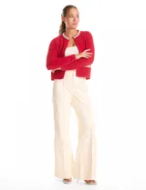 Chaqueta de tejido mohair color rojo, con cuello a la base decorado con bordado de perlas y canutillos. Presenta cierre frontal con broche interno, bolsillos simulados y detalles de apliques brillantes en los bordes.