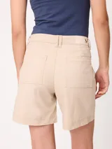 Short negro de gabardina con pinzas delanteras, bolsillos laterales y cierre frontal con botón metálico.