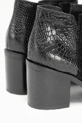 Botín elegante negro confeccionado en cuero tipo gamuza, con tacón medio grueso y talón con textura en relieve tipo reptil.