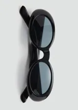 Gafas de sol con diseño ovalado y montura de pasta color negro, con cristales oscuros.