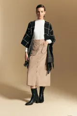 Poncho abierto de tejido de punto con diseño de cuadros grandes en contraste. Presenta un patrón reversible en tonos negro y marrón, con un estilo envolvente y versátil.