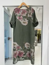 Vestido midi verde militar con estampado de flores rosadas, de manga corta con vuelta, cuello en V y detalles de botones circulares con cordones en la parte delantera.
