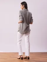 Camisa celeste de tencel con cuello con solapa, abertura central con botones ocultos, bolsillos delanteros y mangas largas regulables con presilla y botón.