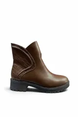 Botas cortas de cuero sintético color marrón, con suela track negra y detalle de textura símil cocodrilo en el lateral.