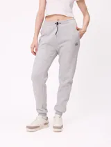 Pantalón tipo babucha de algodón y poliéster en color gris melange. Presenta cintura elástica con cordón ajustable, puños elásticos en los tobillos y logo de la marca bordado en la parte frontal.