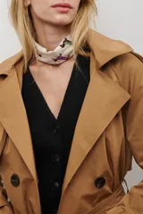 Trench coat negro de corte midi, con cuello solapa, cierre frontal cruzado con botones y cintas ajustables en los puños.