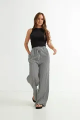 Pantalón palazzo de algodón a rayas verticales blancas y negras, con cintura alta y cordón ajustable.