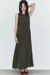 Vestido midi de tejido fluido en color verde oscuro, con cuello redondo y diseño sin mangas. Presenta un corte entallado en el torso que se abre en una falda evasé con pliegues en el bajo. Incluye cierre lateral con cremallera oculta y abertura con botón en la espalda.